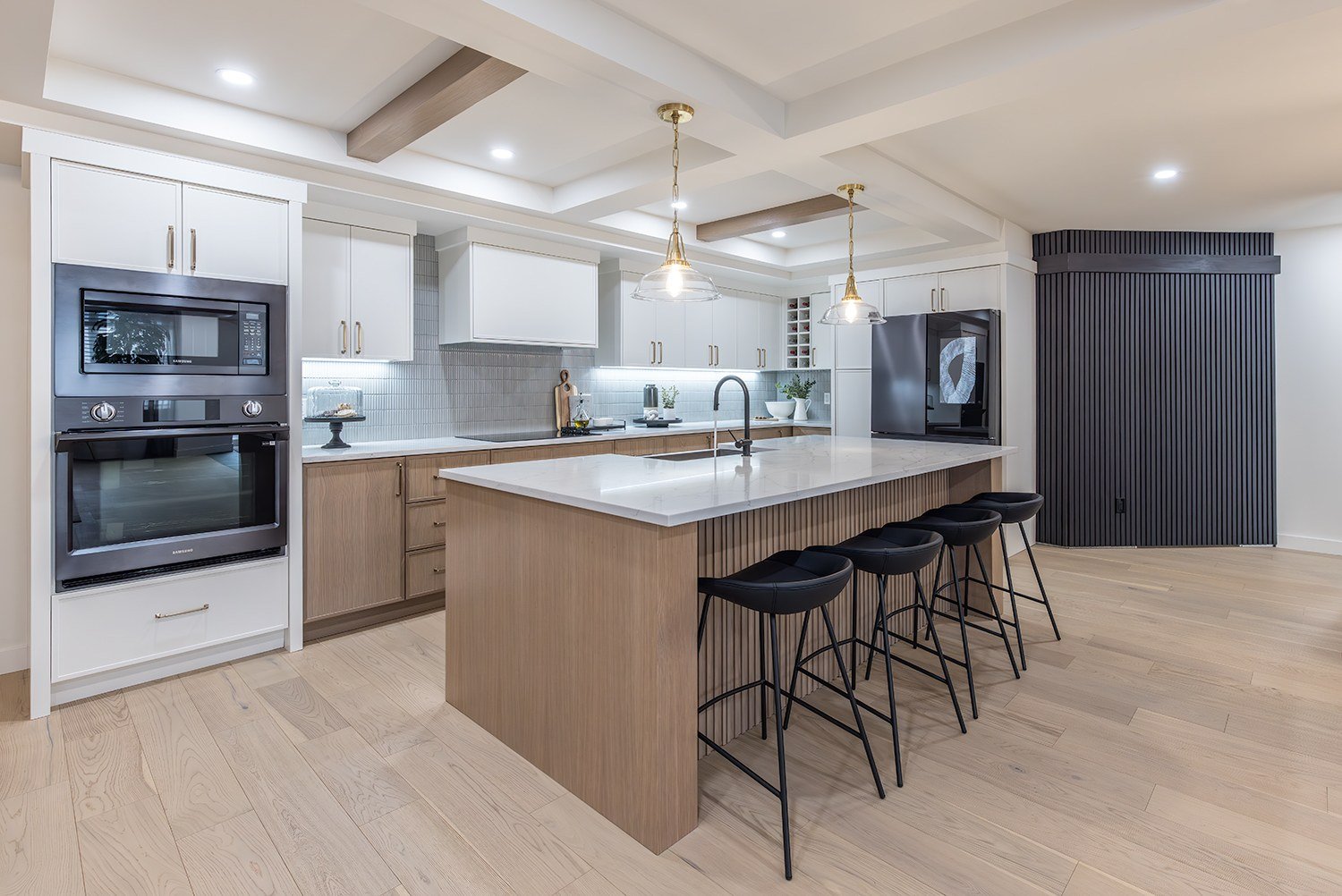 Display kitchen with island seating and built-in ovens