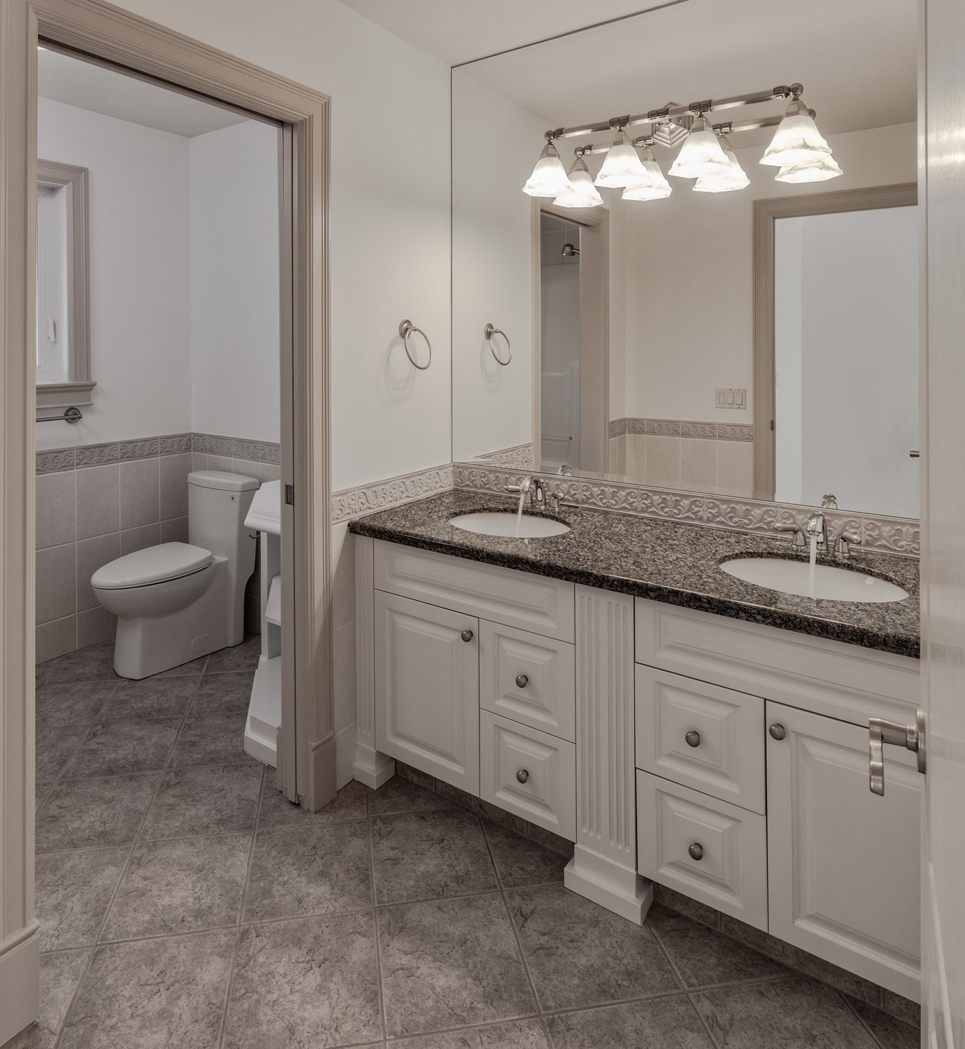 A modern bathroom with a minimalist tap, sleek showerhead, elegant light fittings, and smart storage solutions.
